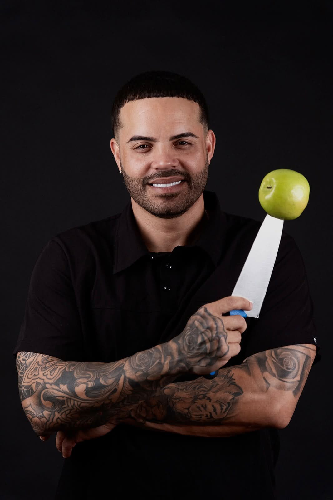 Chef Nelson Cartagena sosteniendo un cuchillo con una manzana verde