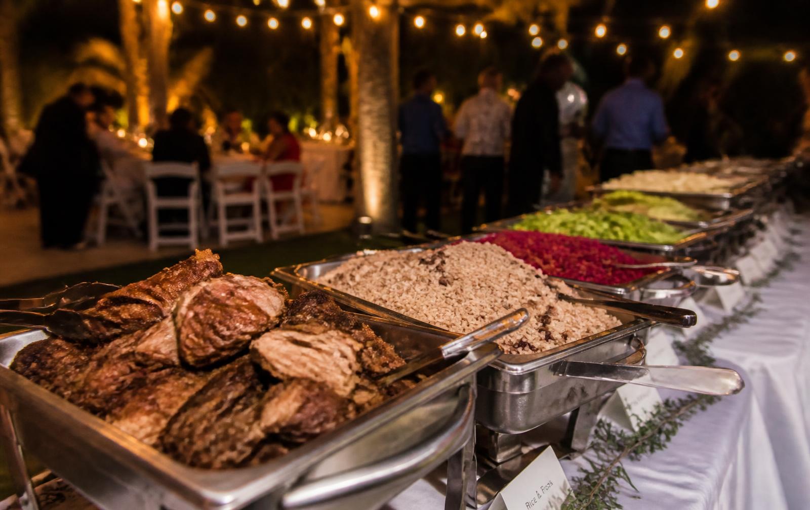 Mesa de eventos con bandejas de carnes, arroces y ensaladas de Chef Carta